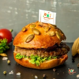 Бургер із котлетою з яловичини, карамелізованою цибулею і домашньою аджикою