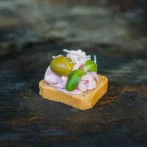 Канапе з рожевим хумусом і оливкою на тостику Мельба